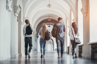Four students walking down the hall at school