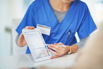 Nurse showing a patient nutrition facts on a clipboard