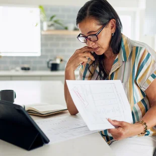 A women looking at medical bills at kitchen table