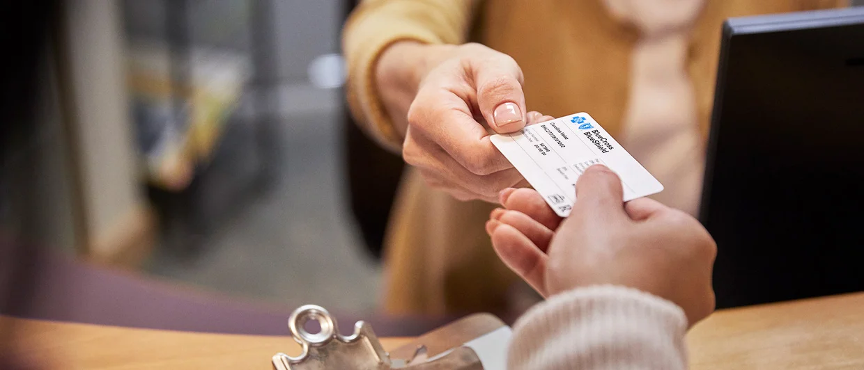 person handing BCBS card to another person