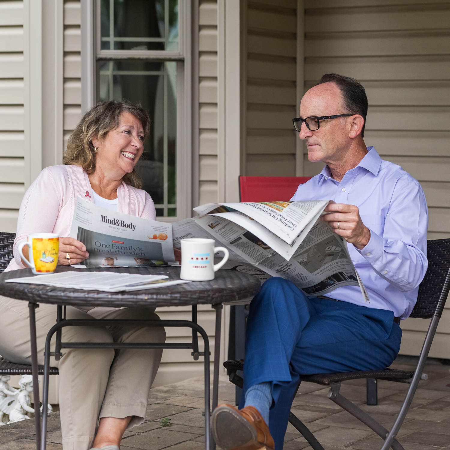 Two adults read newspapers on a porch, reflecting on health insurance