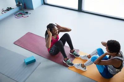 Man and woman doing sit ups in a gym
