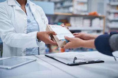 Pharmacist handing a bag to a customer