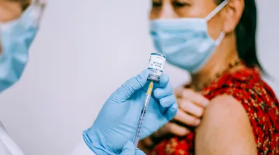 Woman in a mask about to get vaccinated