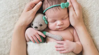 A newborn baby being held softly