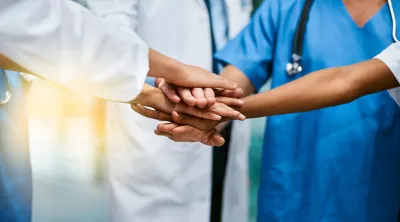 Doctors holding hands as a team
