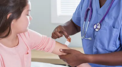 Child receiving a vaccination by a nurse