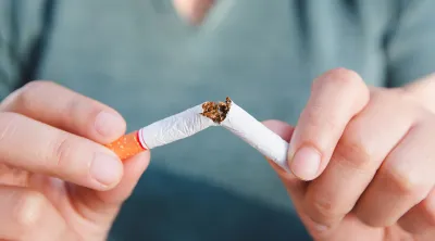 Person breaking a cigarette in half