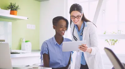 Doctor looking at a tablet computer with her patient