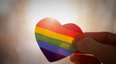 hand holding rainbow colored heart