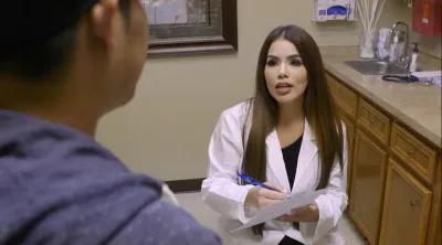 Doctor speaking to her patient while taking notes