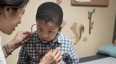 A primary care physician examines a child.