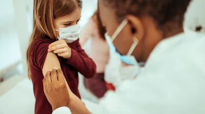 Young girl receiving a vaccination from a doctor