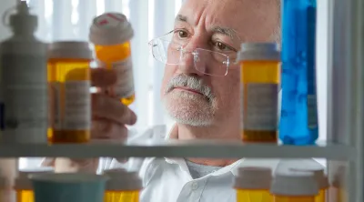 Pharmacist looking at bottles of prescription pills