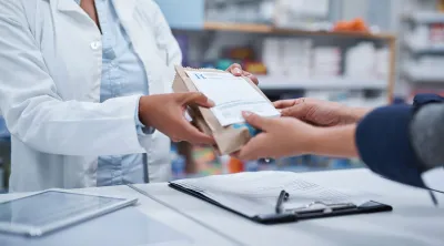 Pharmacist handing a bag to a customer