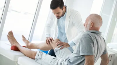 Doctor checking patients knee