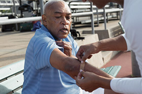 Elderly man getting a band aid